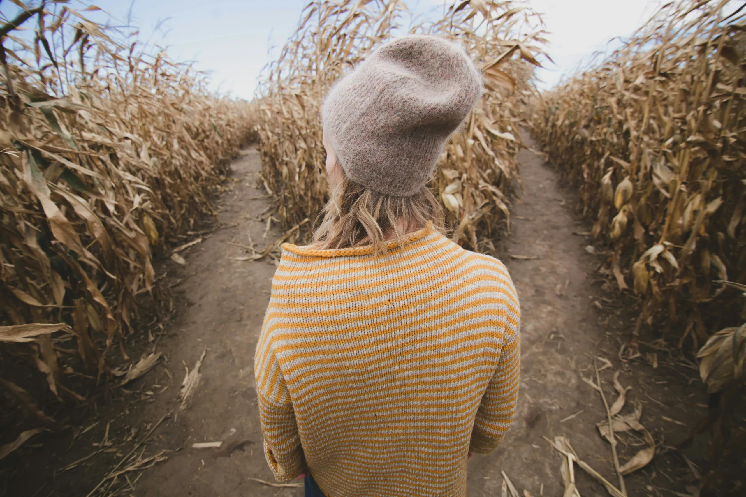 Woman deciding which way to go in a dry corn maze.